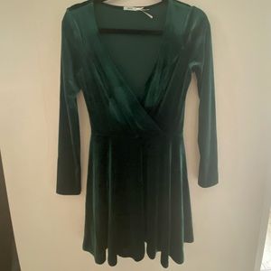 Green velvet party dress with plunge neck and long sleeves.